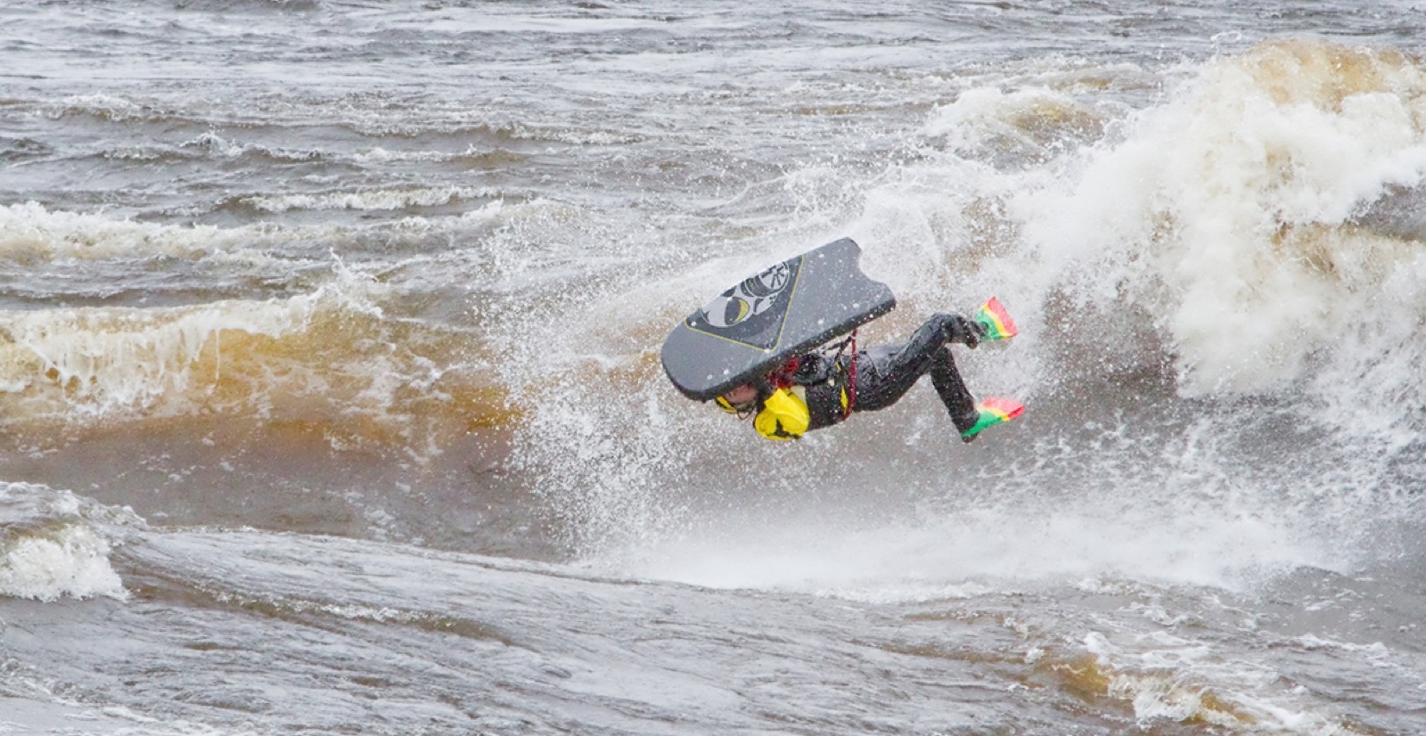 Riverboarder throwing an aerial varial off a wave