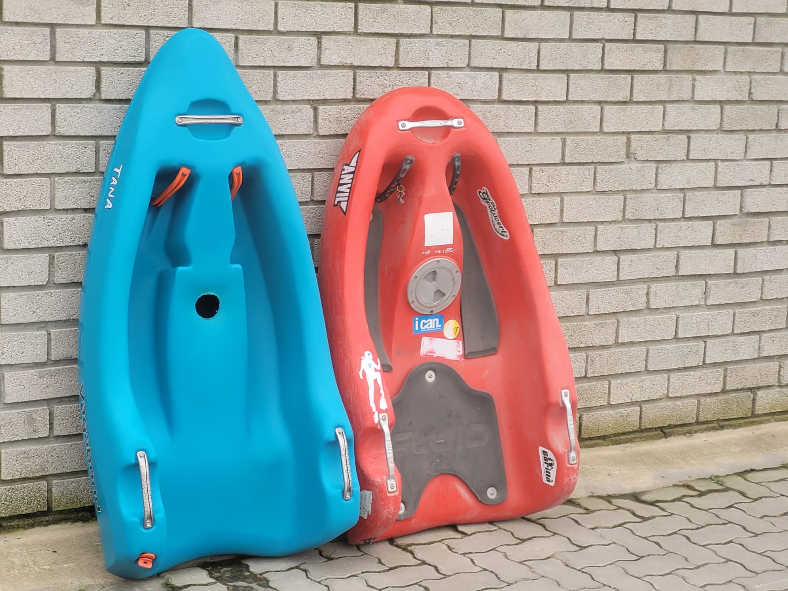 Blue pre-production Tana standing next to a well-used red Fluid Anvil riverboard