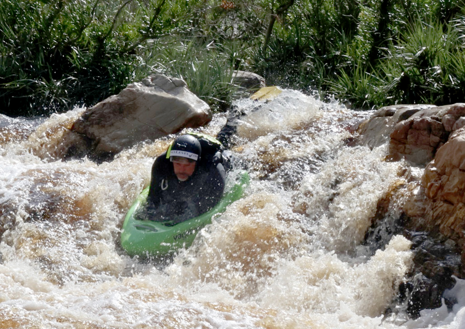 Charl van Rensburg running a steep rapid on the green Tana