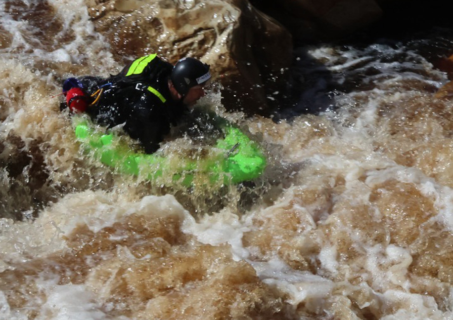 Charl van Rensburg punching through brown flood water on the Tana